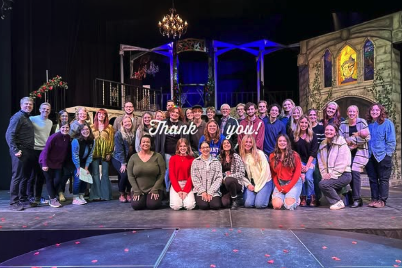 New Life Academy alumni gathered on stage for a group photo during an alumni theater night event.