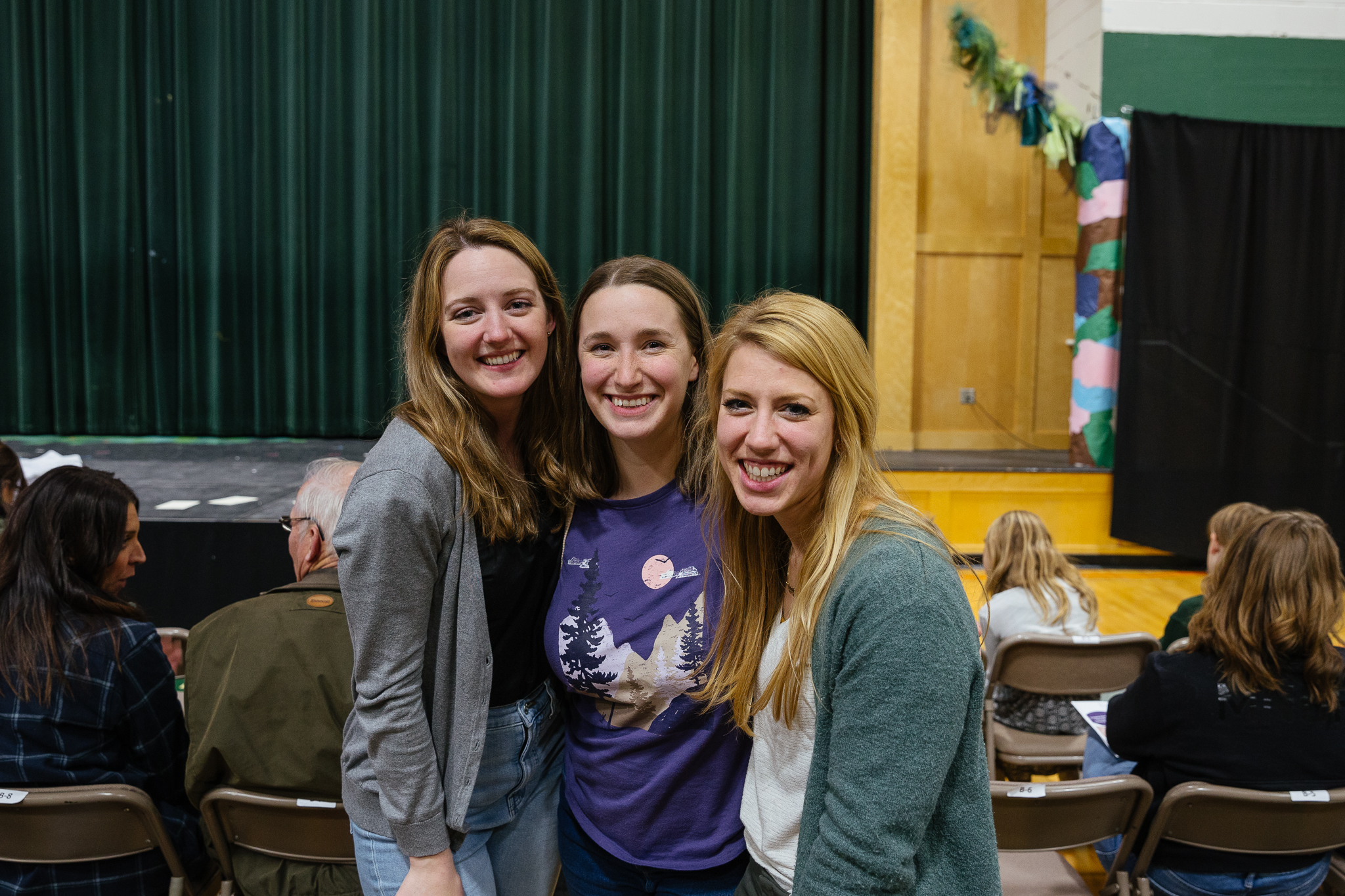 Attendees posing for a photo in the auditorium during New Life Academy’s Seussical alumni night.