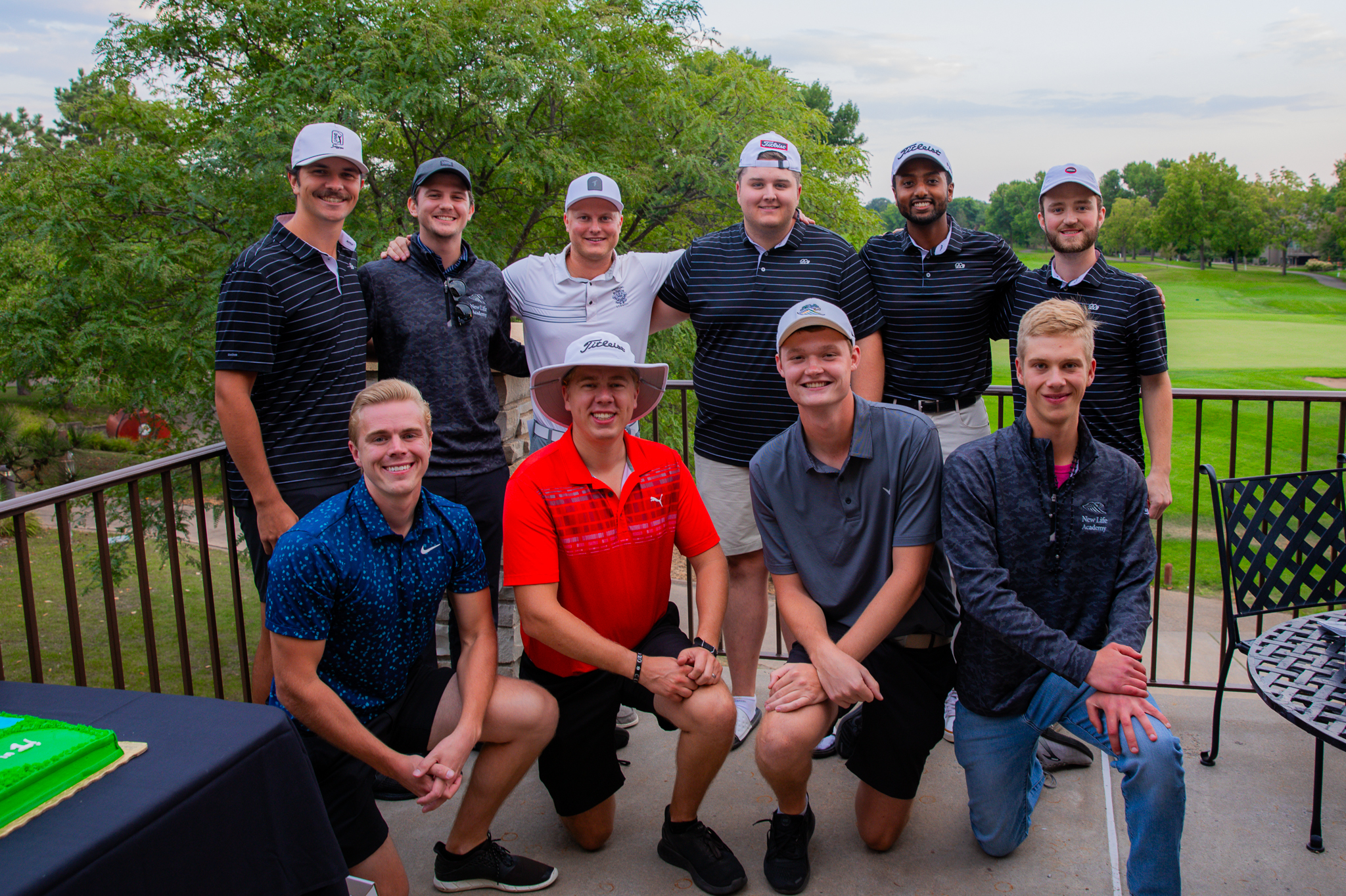New Life Academy alumni gathered outdoors at a golf event during an alumni reception.