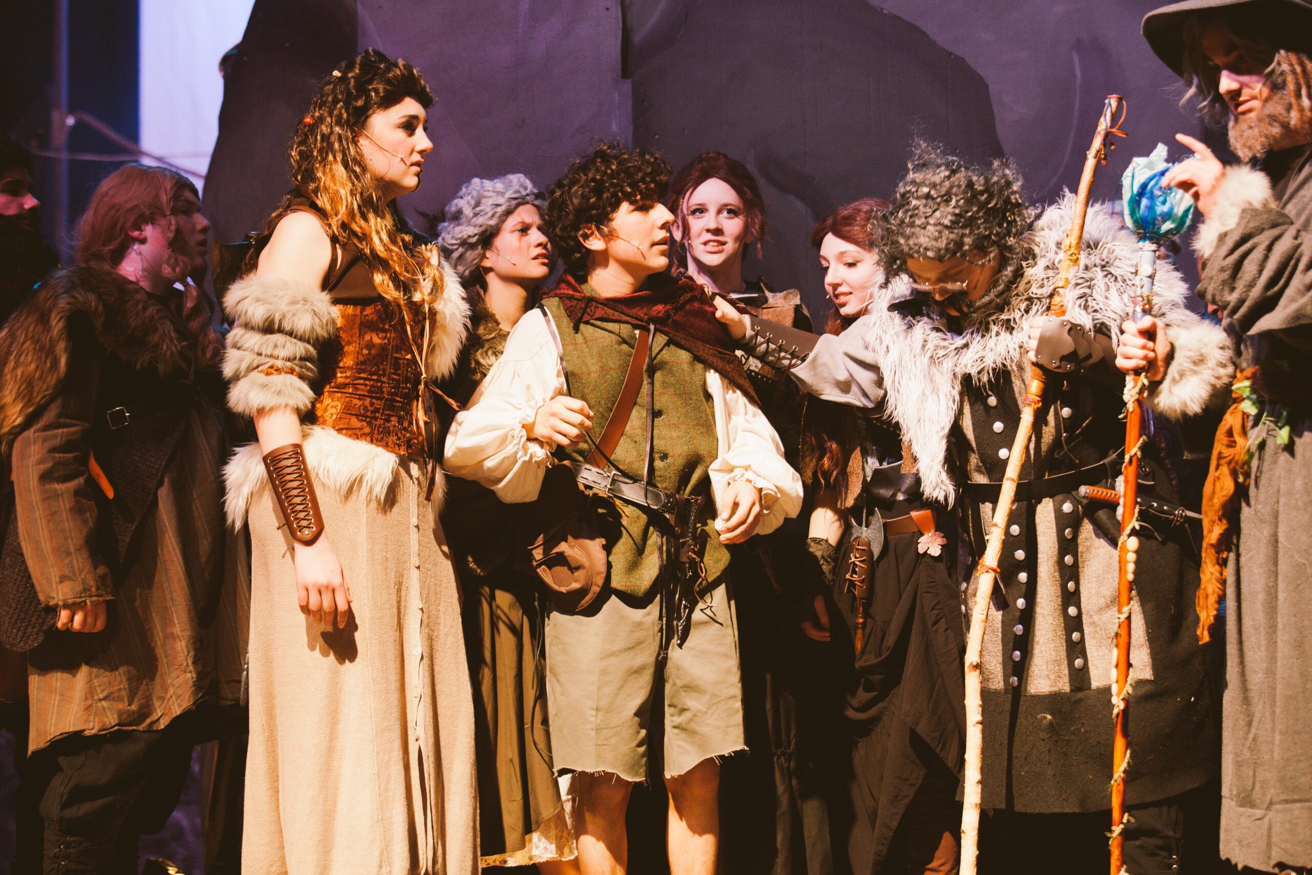 New Life Academy theatre cast performing a dramatic ensemble scene in the school’s production of The Hobbit, wearing detailed fantasy costumes.