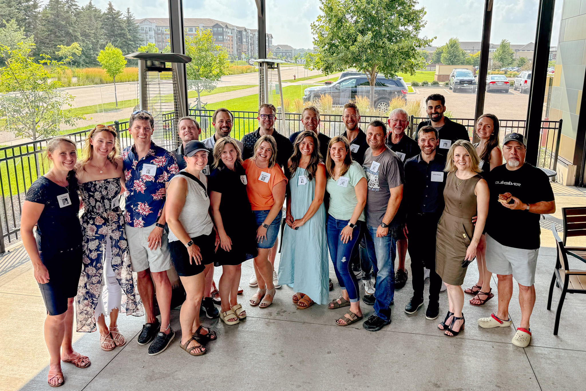 New Life Academy alumni standing together at a class reunion event held outdoors under a covered patio.