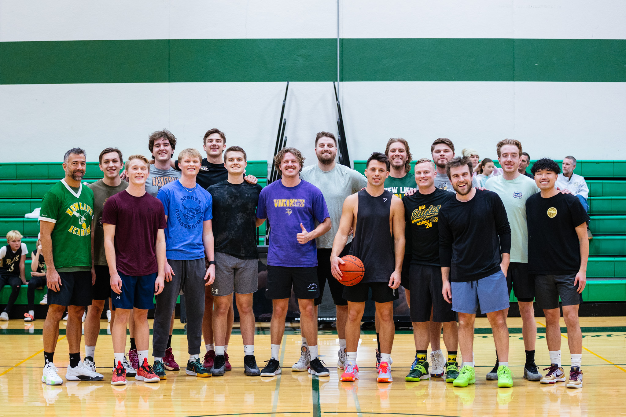 New Life Academy alumni gathered on the gym court for a friendly basketball game during an alumni event.