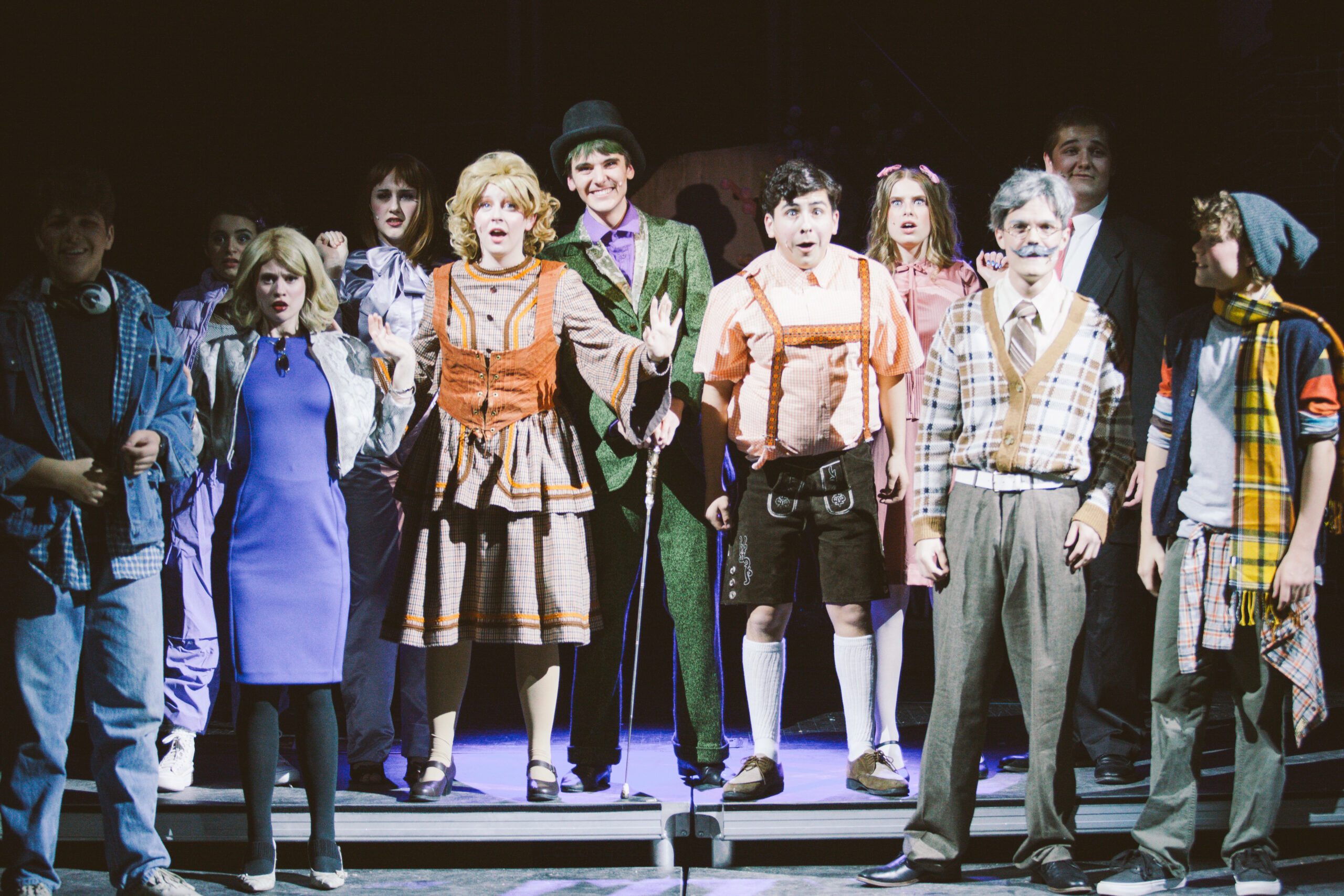 New Life Academy theatre cast performing an ensemble scene in the school’s production of Willy Wonka, wearing coordinated period-style costumes.