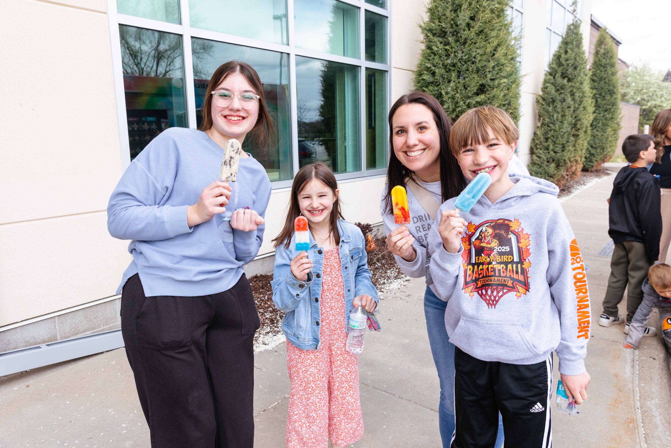 A family enjoys a community event at New Life Academy, connecting with other families outside the school in Woodbury, Minnesota.
